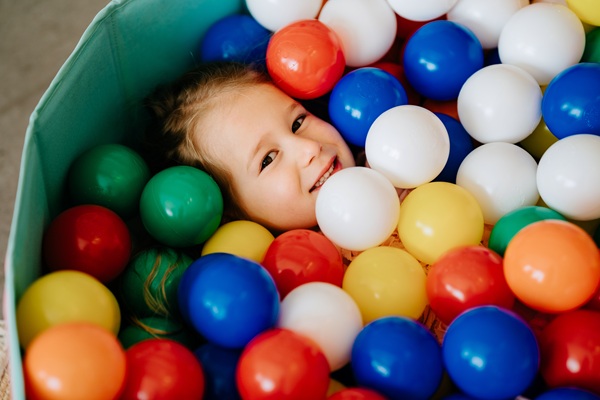 Mosolygó gyerek színes labdák között